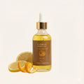 Bottle of Citrus Body Oil with lemons on a light background