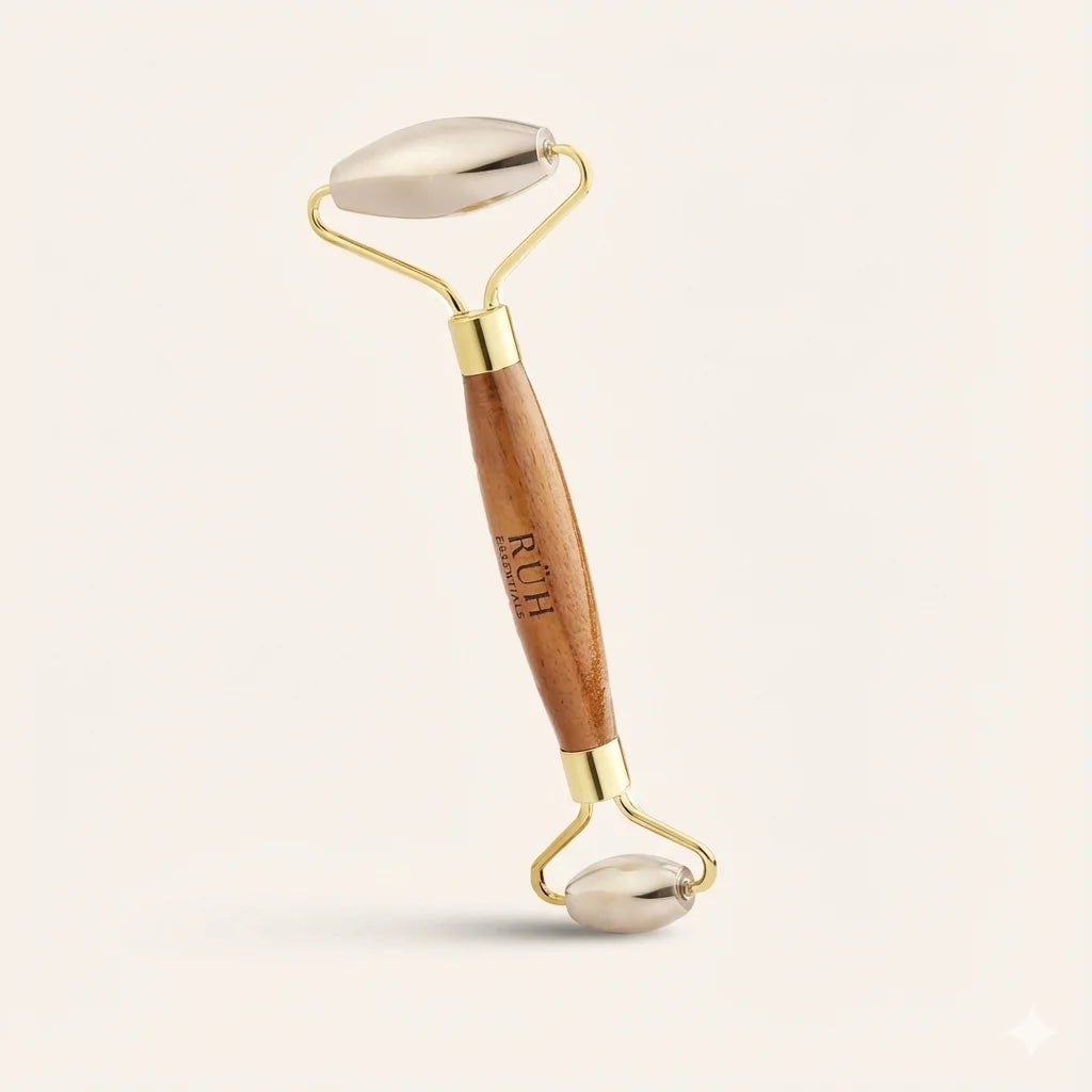 Facial roller with wooden handle and gold Bronze accents on a light beige background
