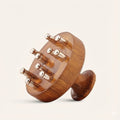 Wooden cylindrical Head Massager with Bronze knobs on a beige background