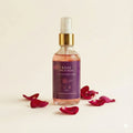 Rose face mist bottle with red rose petals on a beige background
