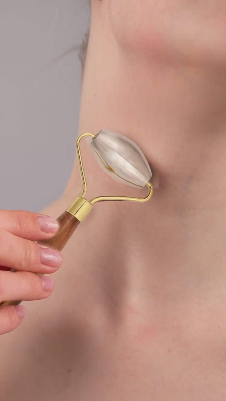 Video of a woman using Kansa Face Roller on her neck